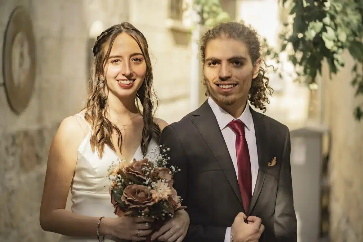 A Man in Black Suit and a Woman in White Dress Smiling