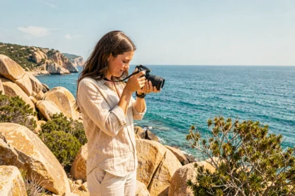 Photographe professionnelle ajustant son appareil photo sur les falaises rocheuses près de Porto-Vecchio en Corse
